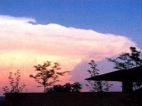 Cumulonimbus clouds are thunderstorm clouds. High winds can flatten the top of the cloud into an anvil-like shape. Cumulonimbus clouds are associated with heavy rain, snow, hail, lightning and even tornadoes. The anvil usually points in the direction the storm is moving.